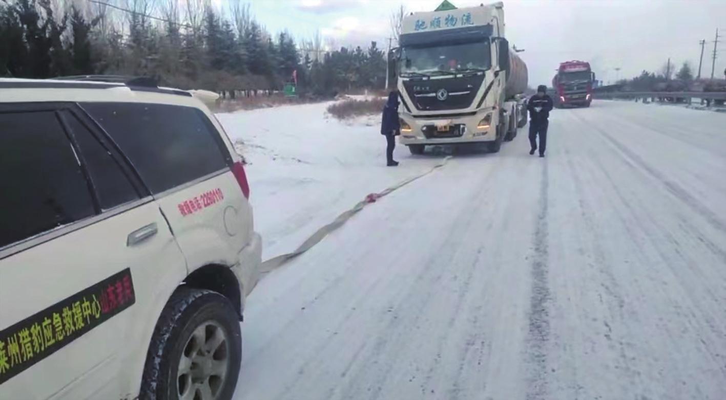 河北30吨油罐车雪地失控横路中 莱州猎豹应急救援中心紧急救助将车拖上坡顶
