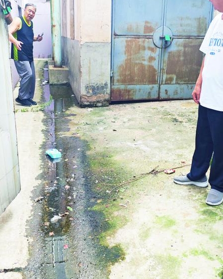 莱山区海滨小区74号楼后堆满垃圾 雨天积水成河四处漫溢