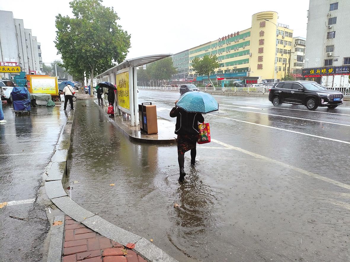 芝罘区机场路一公交站亭一遇下雨变“孤岛” 乘客们要蹚着积水上下车