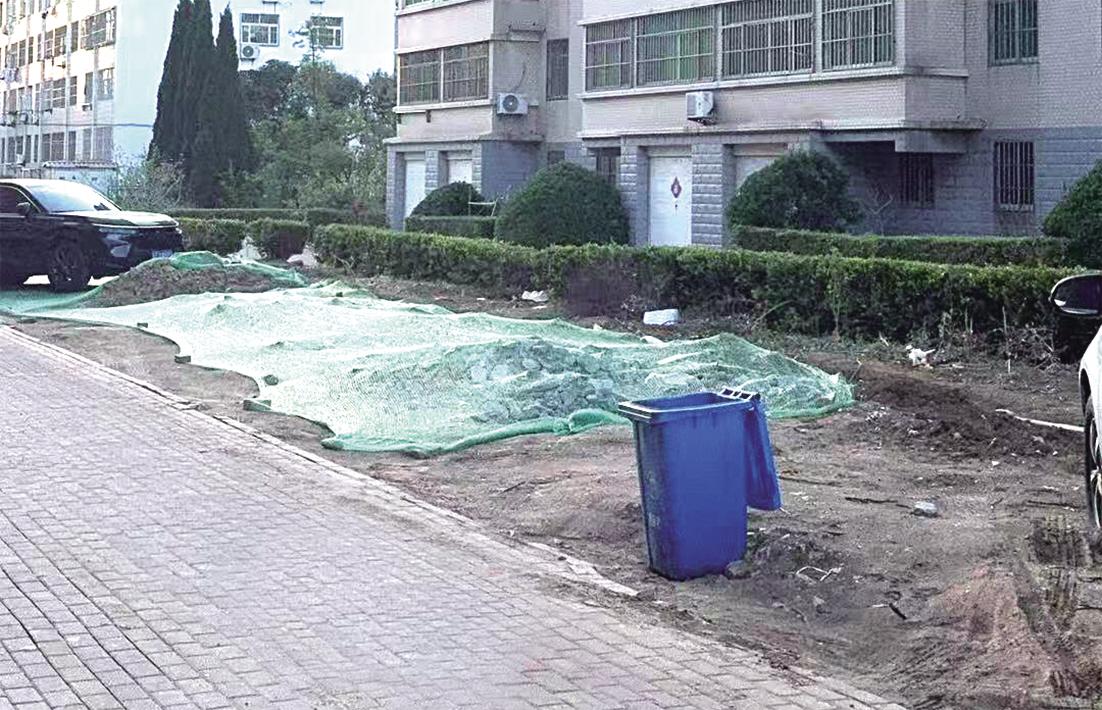 裸露花坛盖上了防尘网 相关部门：集中采购的透水砖到位后，将尽快铺设路面