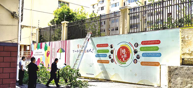 芝罘区木钟厂小区旁树木“卡”墙缝 社区联合物业清理